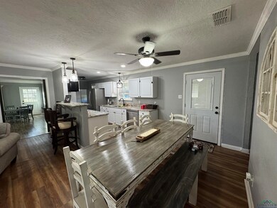 Dining room featuring ceiling fan, sink, dark hard