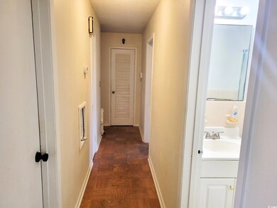 Hall featuring a textured ceiling, dark parquet fl