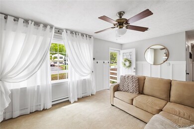 Living room featuring light carpet, ceiling fan, a