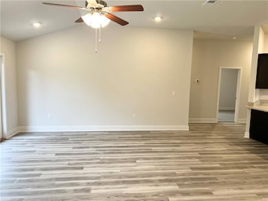 Empty room with light wood finished floors, ceiling fan, recessed lighting, and vaulted ceiling
