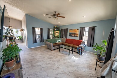 Living area with vaulted ceiling, ceiling fan, and