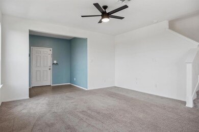 Carpeted spare room featuring a ceiling fan and b