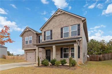 Craftsman house with a porch, brick siding, driveway, and an attached garage