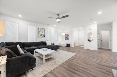 Living room with light hardwood / wood-style floors and ceiling fan