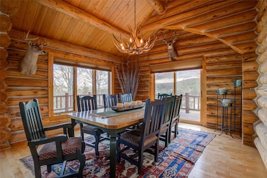 Dining area with a mountain view, wood ceiling, hardwood / wood-style flooring, and an inviting chandelier
