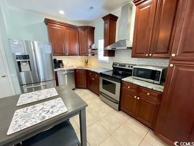 Kitchen featuring tasteful backsplash, wall chimne