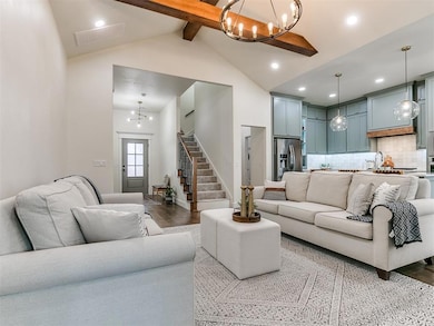 Living room with high vaulted ceiling, a notable chandelier, wood-type flooring, and beamed ceiling