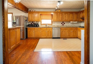 Kitchen with a textured ceiling, light stone count