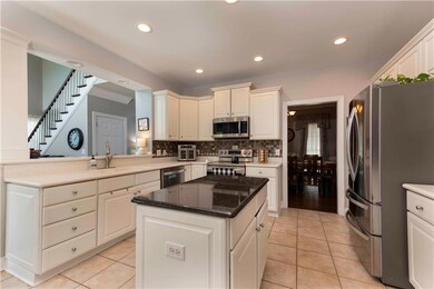 Kitchen with appliances with stainless steel finishes, backsplash, a center island, light tile patterned floors, and recessed lighting