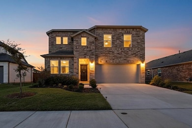 View of front facade with driveway, a yard, brick siding, and a garage