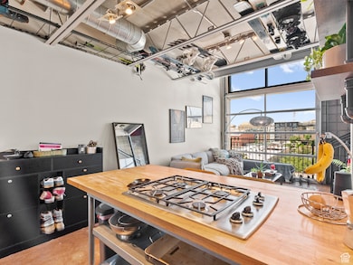 Kitchen with stainless steel gas cooktop and butcher block countertops
