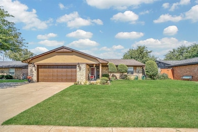 Ranch-style house with a front lawn, driveway, and a garage