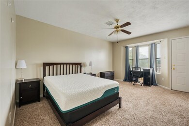 Bedroom with ceiling fan, desk with rolling chair,