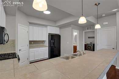 Kitchen with black appliances, hardwood / wood-sty