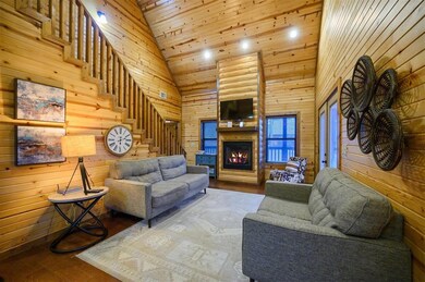 Living room featuring wooden walls, high vaulted c
