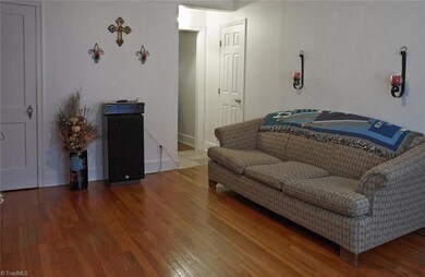 Beautiful hardwoods and wide moldings add lots of charm in living room.  Large coat closet on left. Closed door on upper right is a full bath.