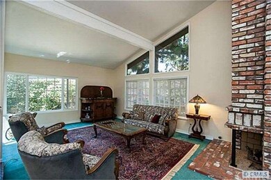 Formal living room with brick fireplace enjoys a w