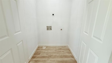 Washroom featuring light wood finished floors, lau