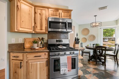 The kitchen has stainless steel appliances, updated tile floors, and is open to the breakfast area.