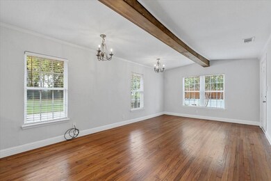 Empty room featuring beamed ceiling, a notable cha