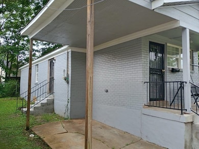 Property entrance featuring brick siding and a patio area