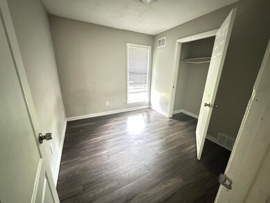 Unfurnished bedroom featuring a closet and dark ha