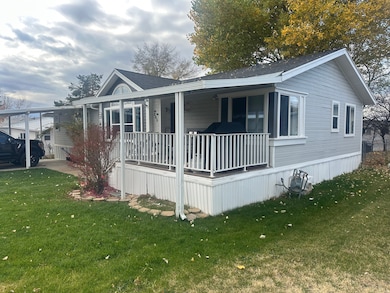 View of home's exterior featuring covered porch, a yard, and roof with shingles