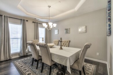 Bright and inviting formal dining with tray ceiling.