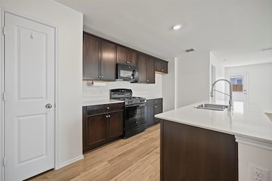 Kitchen featuring visible vents, light wood finish