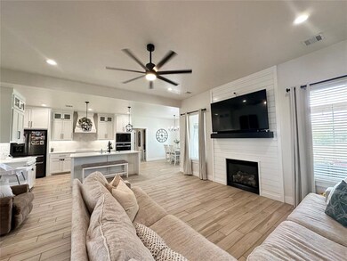 Living room featuring sink, a fireplace, light har