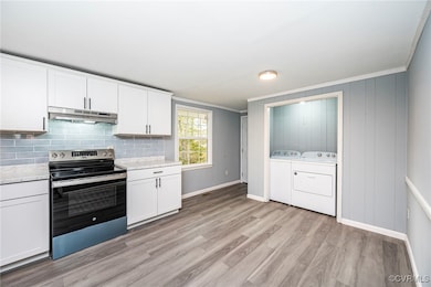 Kitchen with white cabinets, electric stove, light