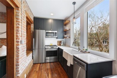Modern luxury kitchen with plentiful natural light and stainless steel appliances.