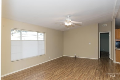 Empty room with dark wood-style flooring and a ceiling fan