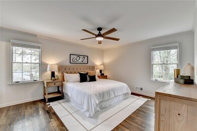 Bedroom with crown molding, wood finished floors, and a ceiling fan