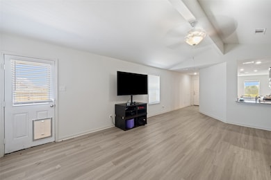Another angle of the living space showing flow toward the kitchen and dining areas.