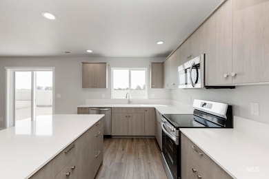Kitchen with stainless steel appliances, recessed lighting, light wood-style floors, modern cabinets, and light brown cabinets