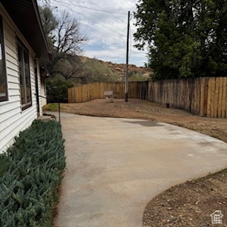 View of fenced backyard from gate or entrance to the front door