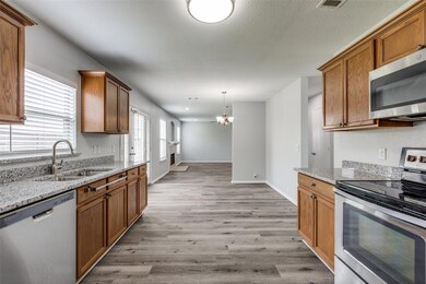 Eat in Kitchen with decorative light fixtures, stainless steel appliances, sink,