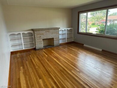 Hardwood floored living room with a baseboard heat