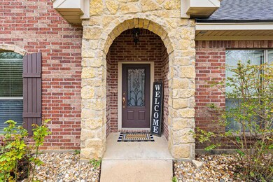 View of exterior entry featuring stone siding, a s