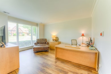 Office space with ornamental molding and wood finished floors