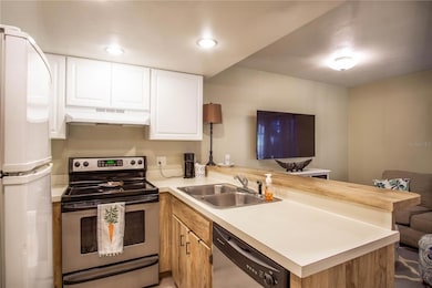 Kitchen with full dishwasher, Range, Fridge.