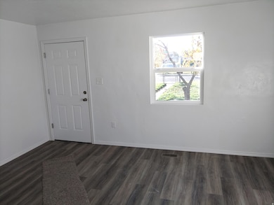 Empty room with baseboards and dark wood-type flooring