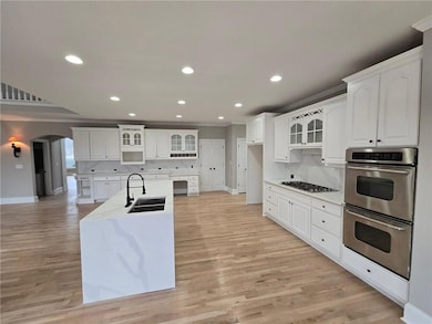 Kitchen featuring backsplash, white cabinetry, sin