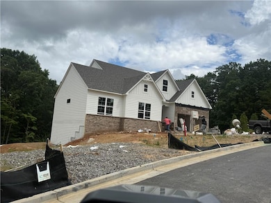 Modern inspired farmhouse with board and batten siding, a shingled roof, and brick siding
