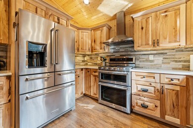 Kitchen featuring tasteful backsplash, wall chimne