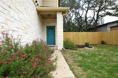 Property entrance featuring fence and stone siding