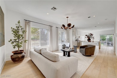 Living room featuring a chandelier, light wood fin
