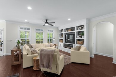 Living room featuring arched walkways, ceiling fan