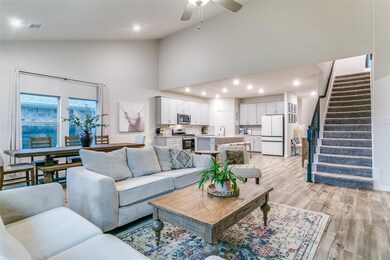 Living room featuring high vaulted ceiling, sink, 